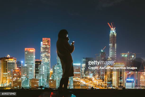 young woman using smartphone in urban city - asien metropole nachtleben stock-fotos und bilder