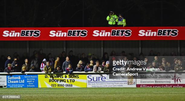Two Police officers watch over the crowd and the game from the roof of the stand during the Vanarama National League match between Sutton United and...