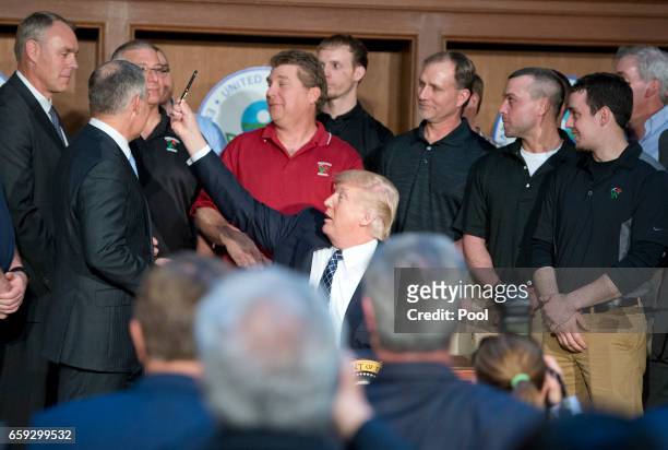 President Donald Trump looks for US Secretary of the Interior Ryan Zinke after signing an Energy Independence Executive Order at the Environmental...