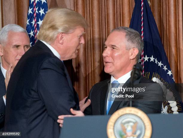 President Donald Trump, left, is greeted by United States Environmental Protection Agency Administrator Scott Pruitt, right, prior to signing an...