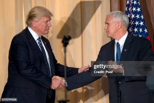 President Donald Trump, left, shakes hands with US Vice President Mike Pence, right, prior to signing an Energy Independence Executive Order at the...