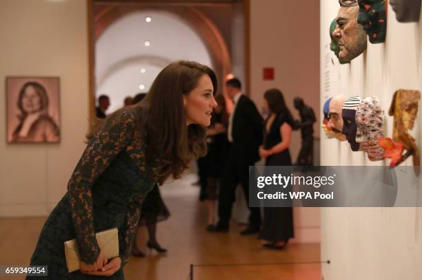 Catherine, Duchess of Cambridge views works of art as she attends the 2017 Portrait Gala at the National Portrait Gallery on March 28, 2017 in...