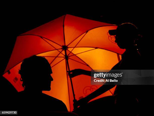 Roger Federer of Switzerland sits between games during his match against Roberto Bautista Agut of Spain during Day 9 of the Miami Open at Crandon...