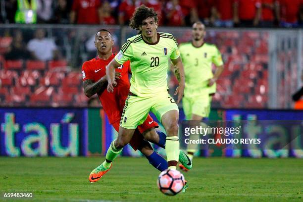 Venezuela's defender Rolf Feltscher runs with the ball ahead of Chile's Eduardo Vargas during their 2018 FIFA World Cup qualifier football match in...