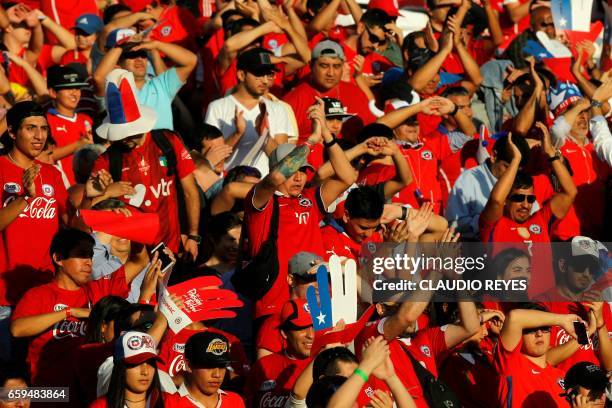 Supporters of Chile cheer for their team during the 2018 FIFA World Cup qualifier football match against Venezuela in Santiago, Chile on March 28,...