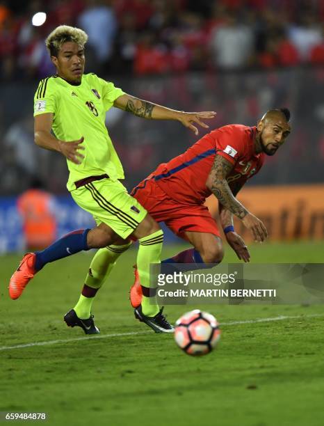 Venezuela's midfielder Adalberto Penaranda vies for the ball with Chile's midfielder Arturo Vidal during their 2018 FIFA World Cup qualifier football...