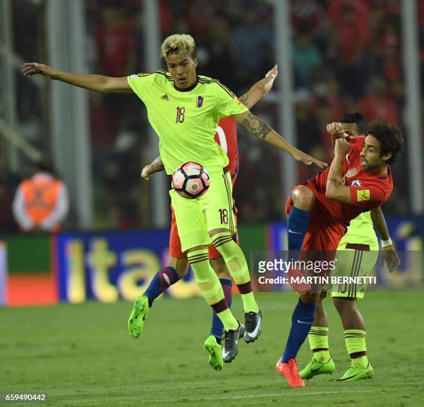 Venezuela's midfielder Adalberto Penaranda jumps for the ball next to Chile's Jorge Valdivia during their 2018 FIFA World Cup qualifier football...