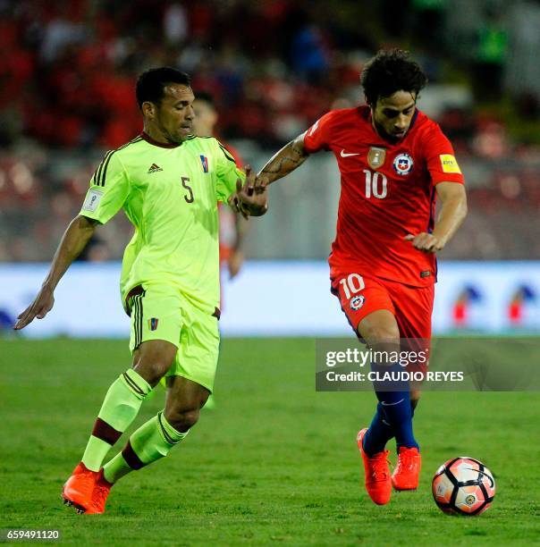 Venezuela's midfielder Arquimedes Figuera pressures Chile's Jorge Valdivia during their 2018 FIFA World Cup qualifier football match in Santiago,...