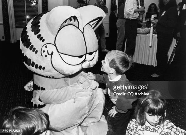 "Garfield"cartoonist Jim Davis present with lots of kids. Brett Miller, shows Garfield his painted face. Hana is in the foreground at a eception in...