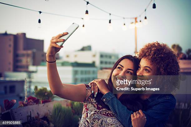 friends taking a selfie on urban rooftop - female friendship stock pictures, royalty-free photos & images