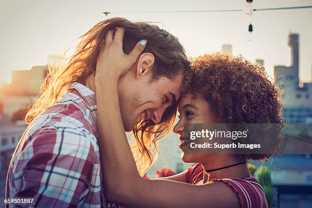 couple embracing on urban rooftop - young couple hugging stock pictures, royalty-free photos & images