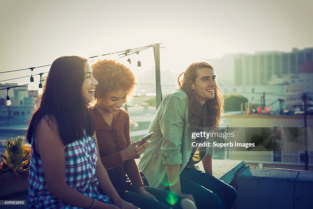 Friends sharing a laugh on urban rooftop