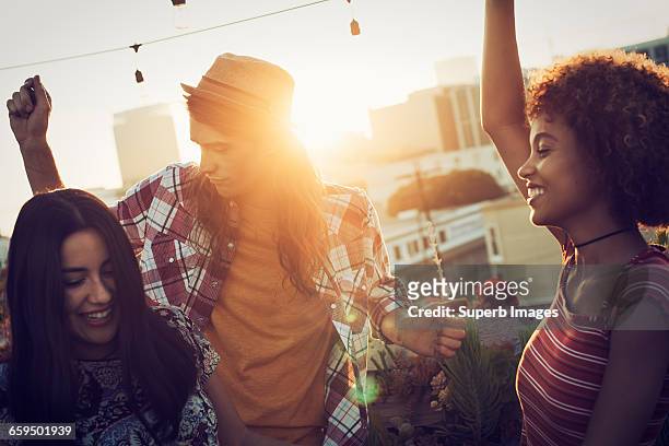 friends dancing on urban rooftop - sunset freinds city stock-fotos und bilder