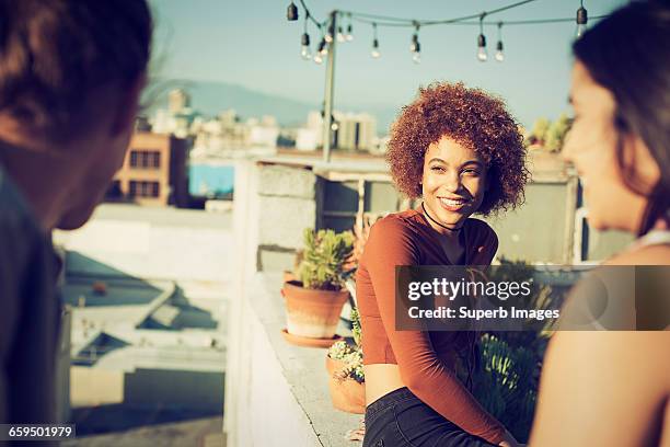 friends hanging out on urban rooftop - sunset freinds city stock-fotos und bilder