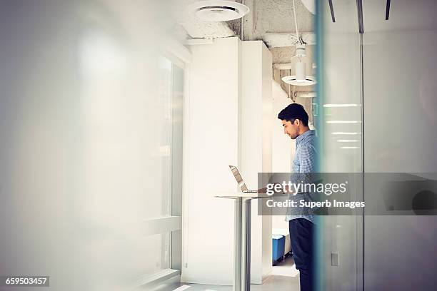 man working on laptop computer in business office - fokus-auf-den-hintergrund stock-fotos und bilder