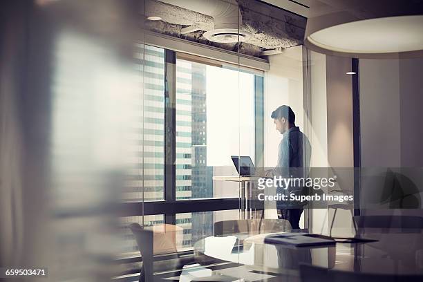man working on laptop in business office - focus on background stock pictures, royalty-free photos & images