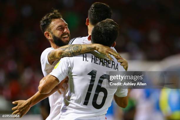 Diego Reyes of Mexico celebrates with teammates after scoring his team's first goal during the fifth round match between Trinidad & Tobago and Mexico...