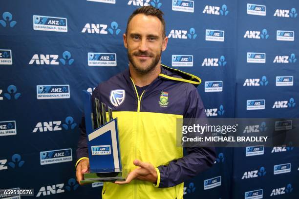 South Africa's captain Faf du Plessis holds the trophy after the day five of the third Test cricket match between New Zealand and South Africa was...