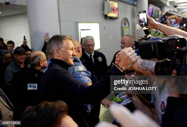 Manchester United midfielder Bastian Schweinstiger greets fans as he arrives at O'hare International Airport on March 28, 2017 in Chicago, Illinois....