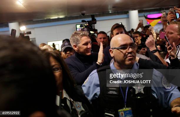 Manchester United midfielder Bastian Schweinstiger greets fans as he arrives at O'hare International Airport on March 28, 2017 in Chicago, Illinois....