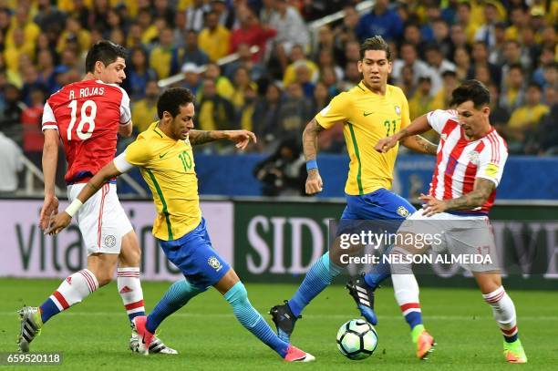 Brazil's forward Neymar vies for the ball with Paraguay's Rodrigo Rojas and Paraguay's midfielder Hernan Perez during their 2018 FIFA World Cup...