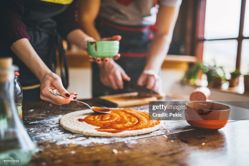 Jong koppel verse pizza maken in de keuken