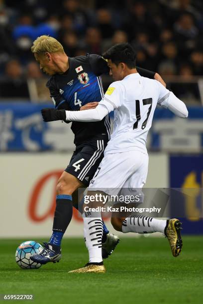 Keisuke Honda of Japan controls the ball under pressure of Tanaboon Kesarat of Thailand during the 2018 FIFA World Cup Qualifier match between Japan...