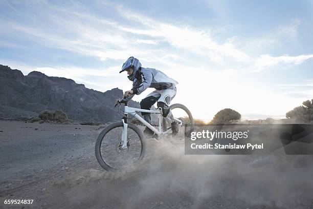 mountain biker speeding through desert - adrenalina fotografías e imágenes de stock