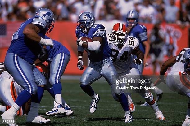 James Stewart of the Detroit Lions carries the ball as he is chased by Gerard Warren of the Cleveland Browns during the game at the Cleveland Browns...