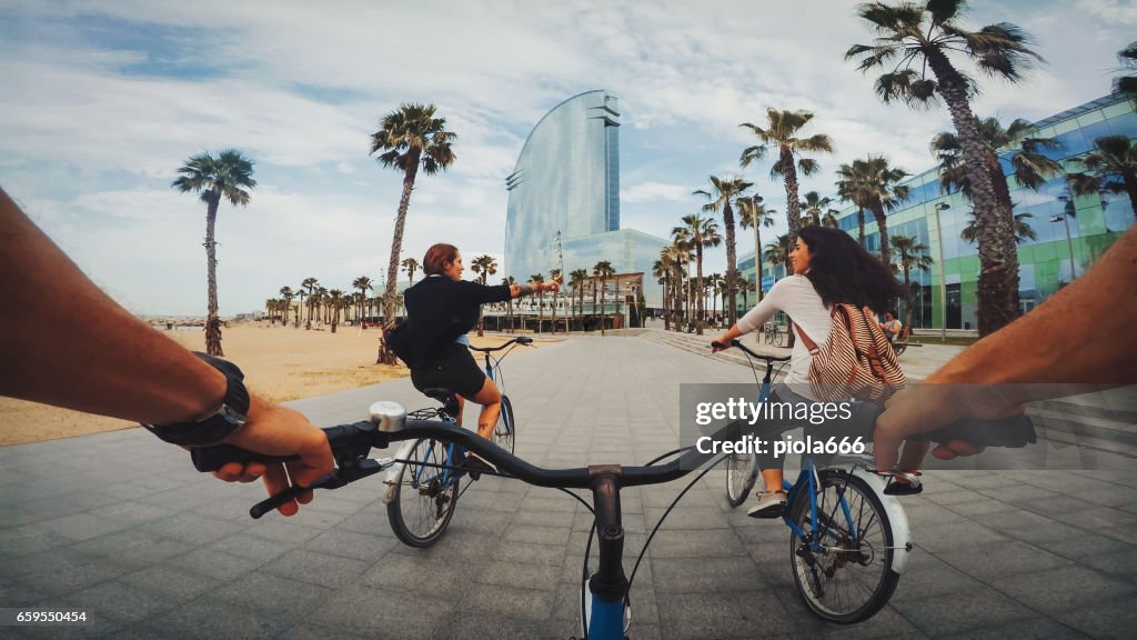 POV bicycle riding with friends at Barceloneta beach in Barcelona, Spain