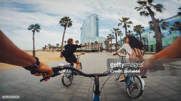 pov bicycle riding with friends at barceloneta beach in barcelona, spain - barcelona spain stock pictures, royalty-free photos & images
