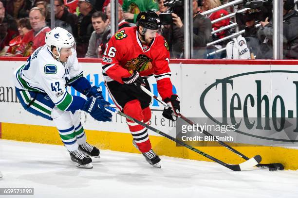 Drew Shore of the Vancouver Canucks and Marcus Kruger of the Chicago Blackhawks chase the puck in the first period at the United Center on March 21,...