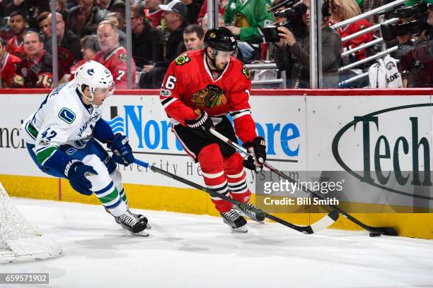 Drew Shore of the Vancouver Canucks and Marcus Kruger of the Chicago Blackhawks chase the puck in the first period at the United Center on March 21,...