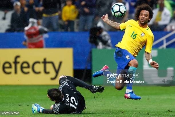 Marcelo of Brazil struggles for the ball with goalkeeper Antony Silva of Paraguay during a match between Brazil and Paraguay as part of 2018 FIFA...