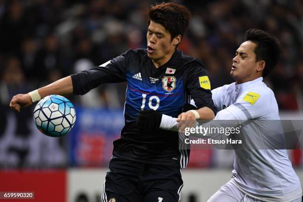 Hiroki Sakai of Japan and Perapat Notechaiya of Thailand compete for the ball during the 2018 FIFA World Cup Qualifier match between Japan and...