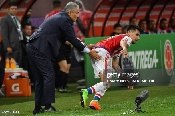 Brazil's team coach Tite helps Paraguay's midfielder Hernan Perez up during their 2018 FIFA World Cup qualifier football match in Sao Paulo, Brazil...