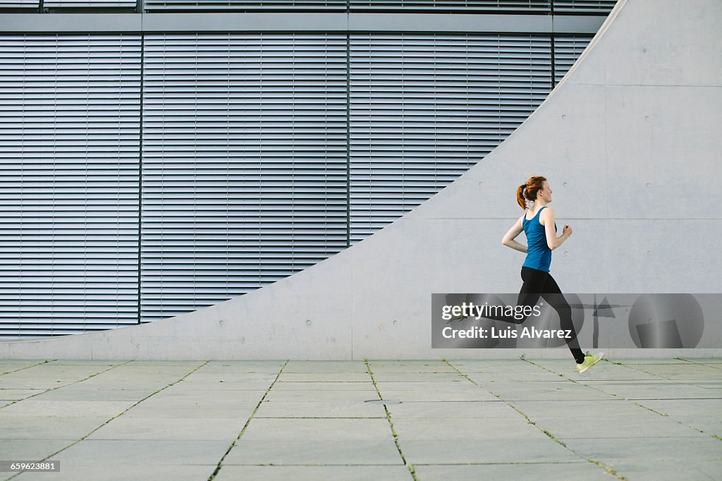 Woman running in front of a building