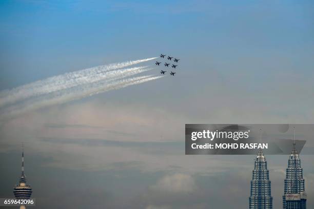 The Black Eagles, the aerobatic team of T-50 jets belonging to South Korea's air force, fly in formation past the Kuala Lumpur Tower and Petronas...