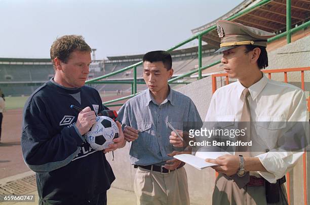 Paul Gascoigne signs a ball for fans during the England football team's tour of Hong Kong and China, China, May 1996.