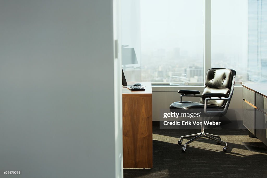 Bright corner office space with desk and chairs