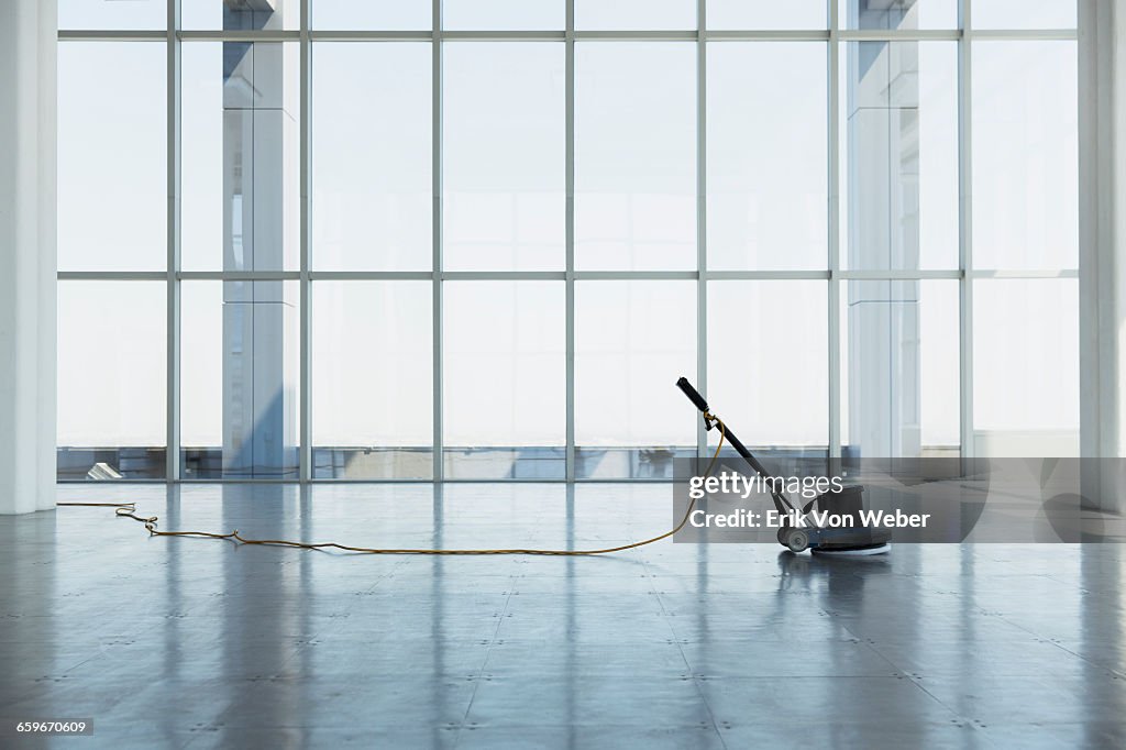 Floor buffing machine in large empty office space