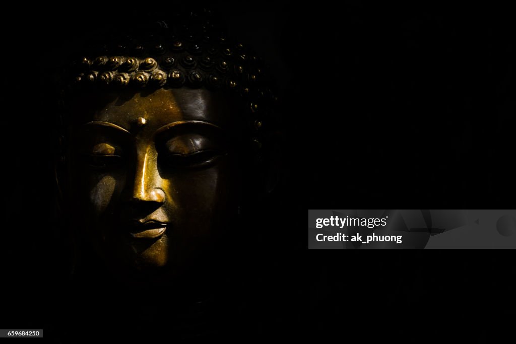 Sunlight on Buddha face against with black background