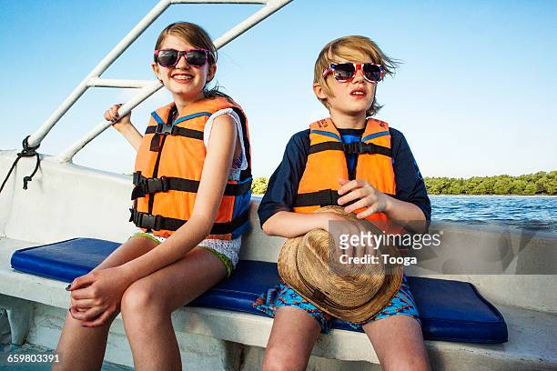 Kids on boat riding with life perservers