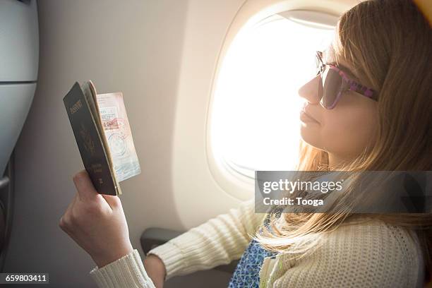 tween girl looking at stamps on passport - passport stamp stock pictures, royalty-free photos & images