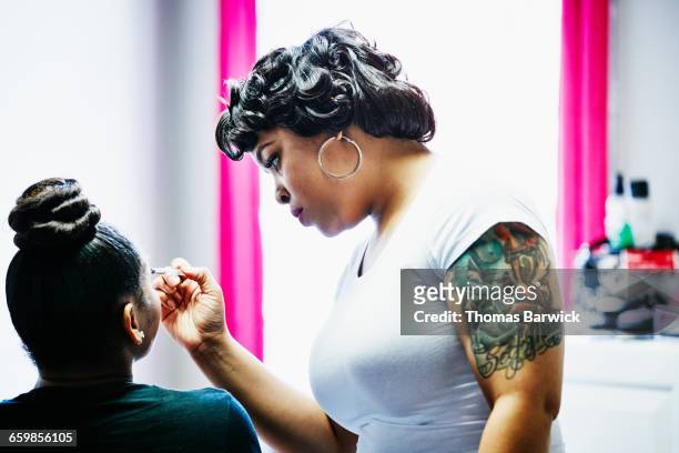 makeup artist applying eye shadow during makeover - prima esperienza foto e immagini stock
