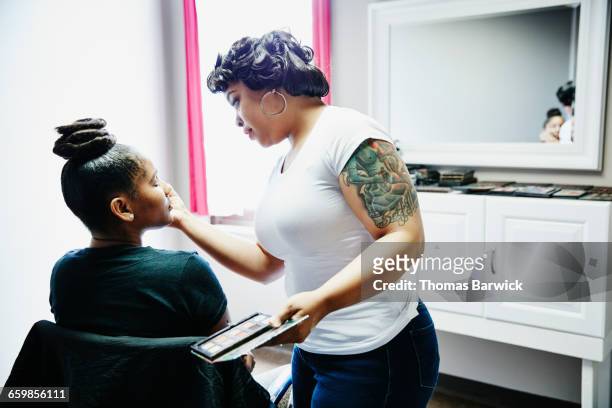 Makeup artist applying eye shadow during makeover