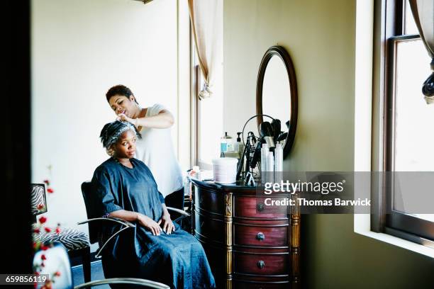 female hairstylist foiling clients hair in salon - black hair salon stock pictures, royalty-free photos & images