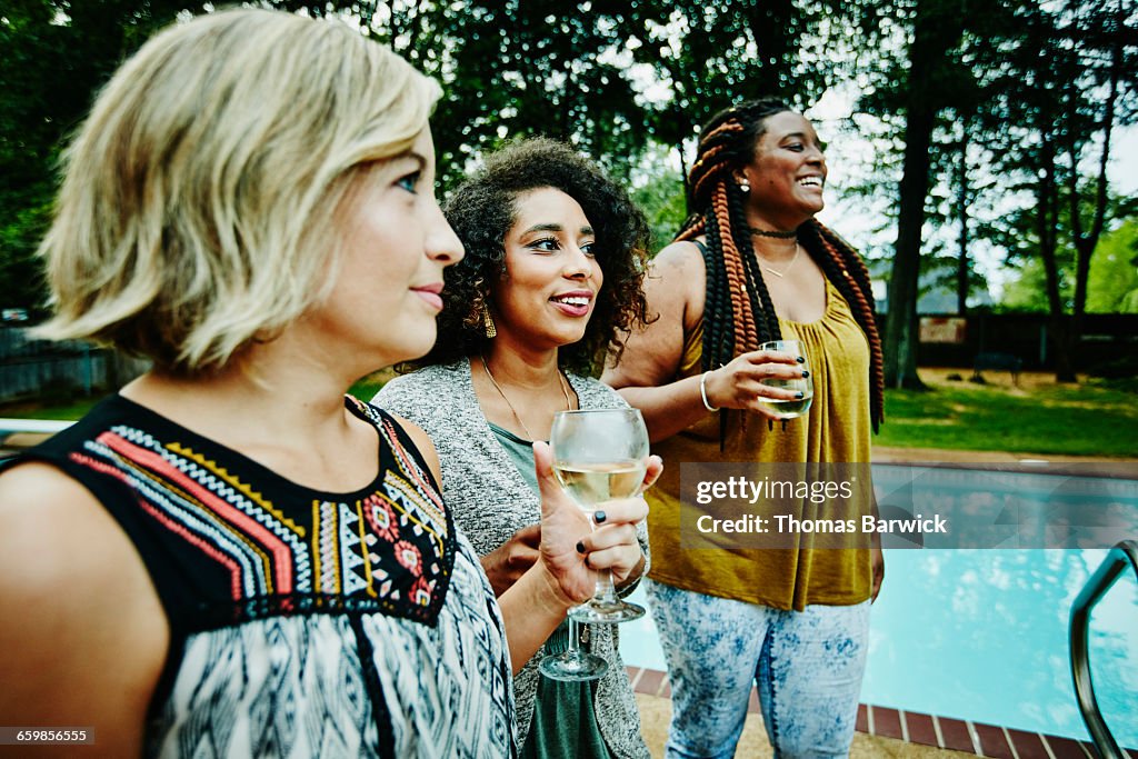 Women sharing wine during backyard party
