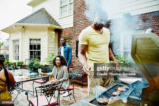 man barbecuing for friends during backyard party - small group of people outdoors food stock pictures, royalty-free photos & images