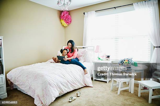 Mother and daughter reading on digital tablet